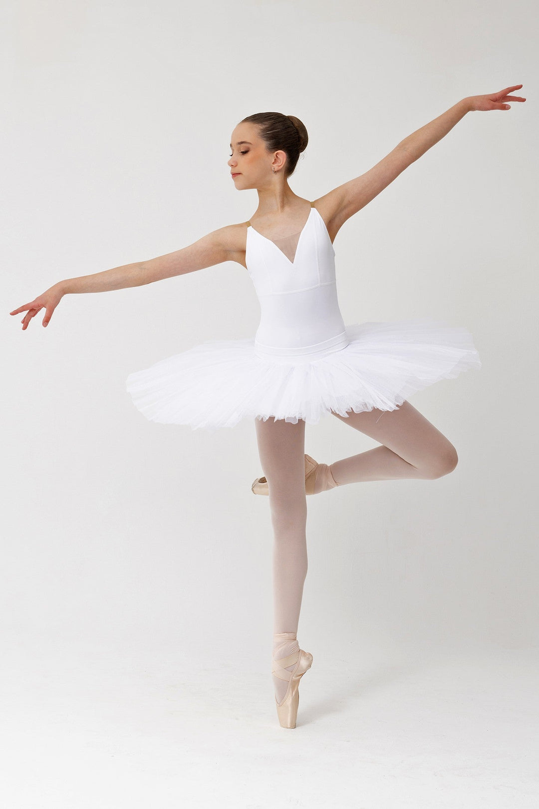 Ballerina in a white tutu posing on a white background