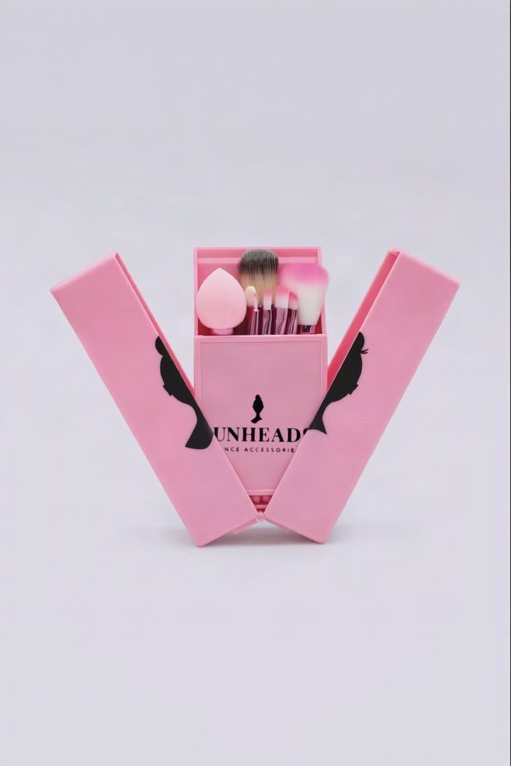 Pink makeup brush set in an open matching case, with makeup sponges and brushes visible inside.